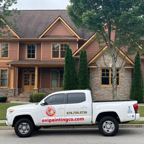 ovipainting service truck in front of a modern house with trees