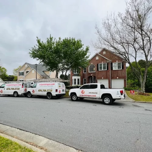 servicing a red brick house with ovipainting service truck