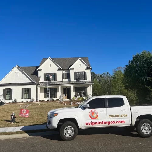 house under renovation with ovipainting service truck